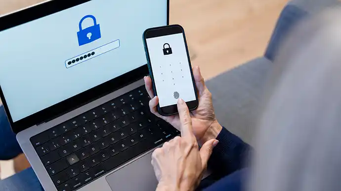 person entering encrypted passwords on a phone and laptop
